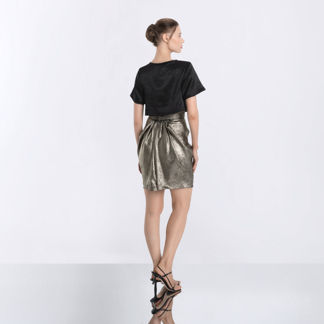Back view of shimmering metallic gold skirt, pleated design with elegant movement by Hong Kong fashion designer Lola Clave