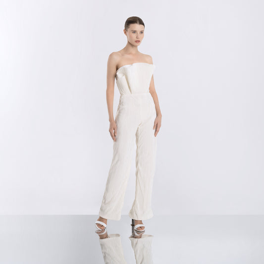 Model wearing a white strapless pleated jumpsuit with wide-leg trousers and a fitted bodice front view