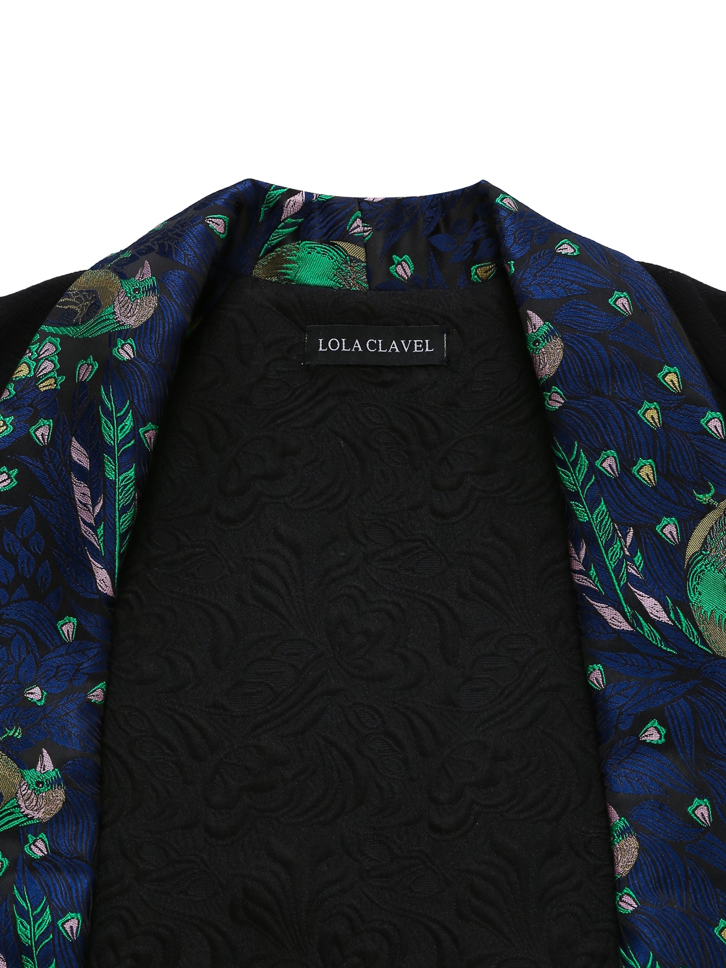 Close-up of the jacquard lapel on the reversible kimono jacket, showcasing an intricate bird and foliage pattern in shades of green, teal, and purple on a midnight blue base