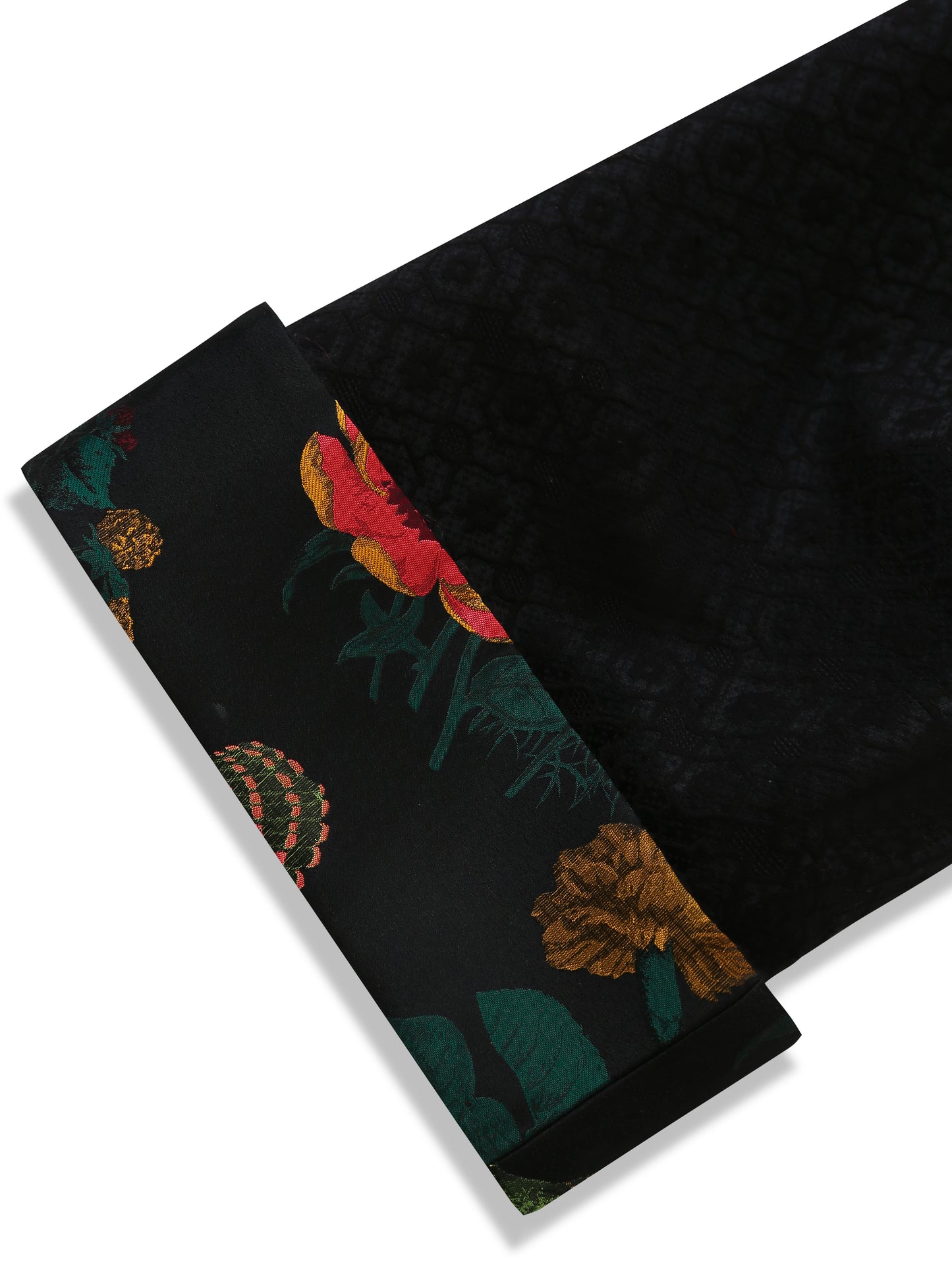 Close-up of the bottom sleeve of the reversible black brocade kimono jacket, showing the clean finish and a peek of the contrasting floral brocade lining