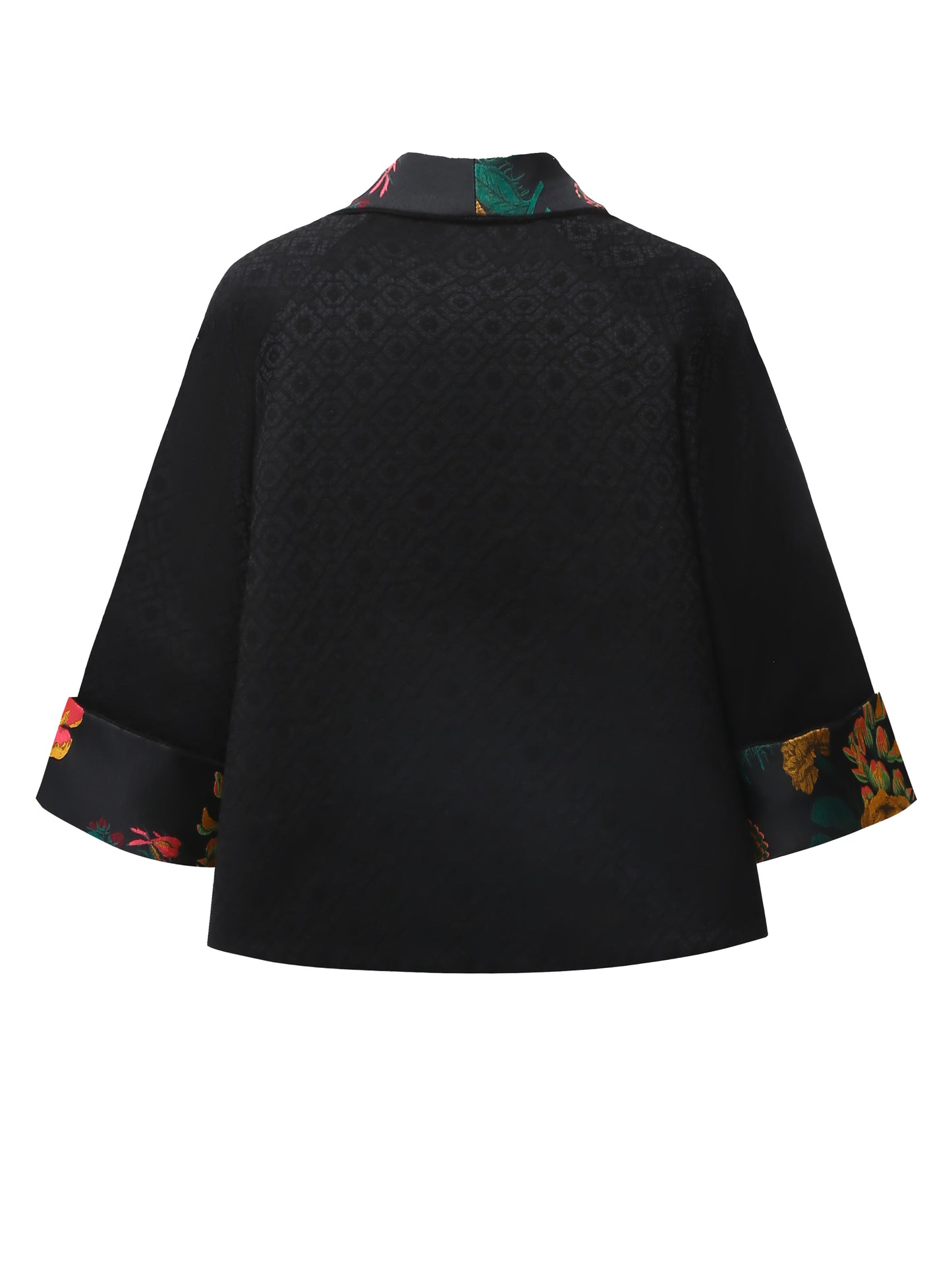 Back view of a reversible black brocade kimono jacket showing the flowing shape and textured woven surface, with no visible trim