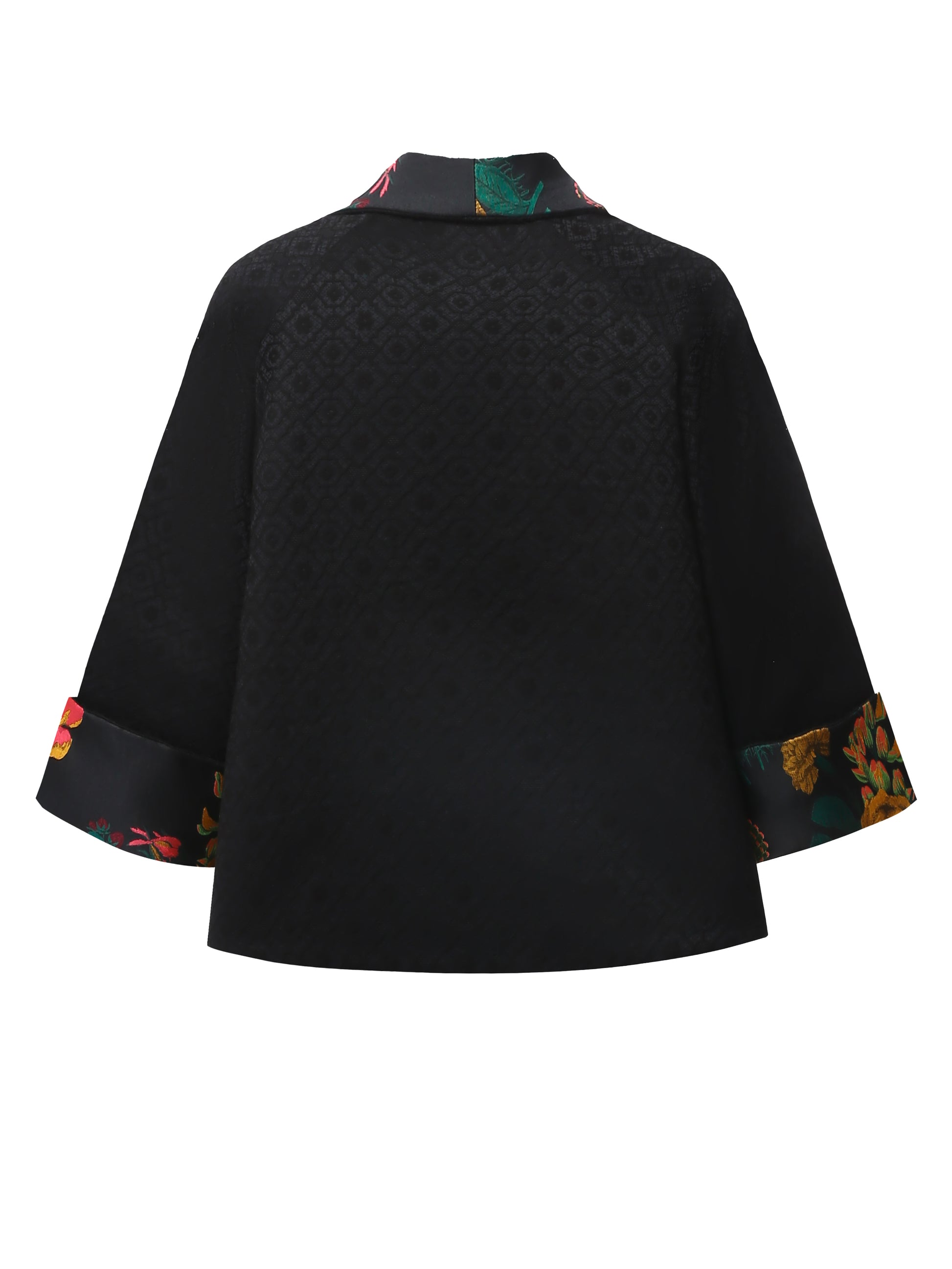 Back view of a reversible black brocade kimono jacket showing the flowing shape and textured woven surface, with no visible trim