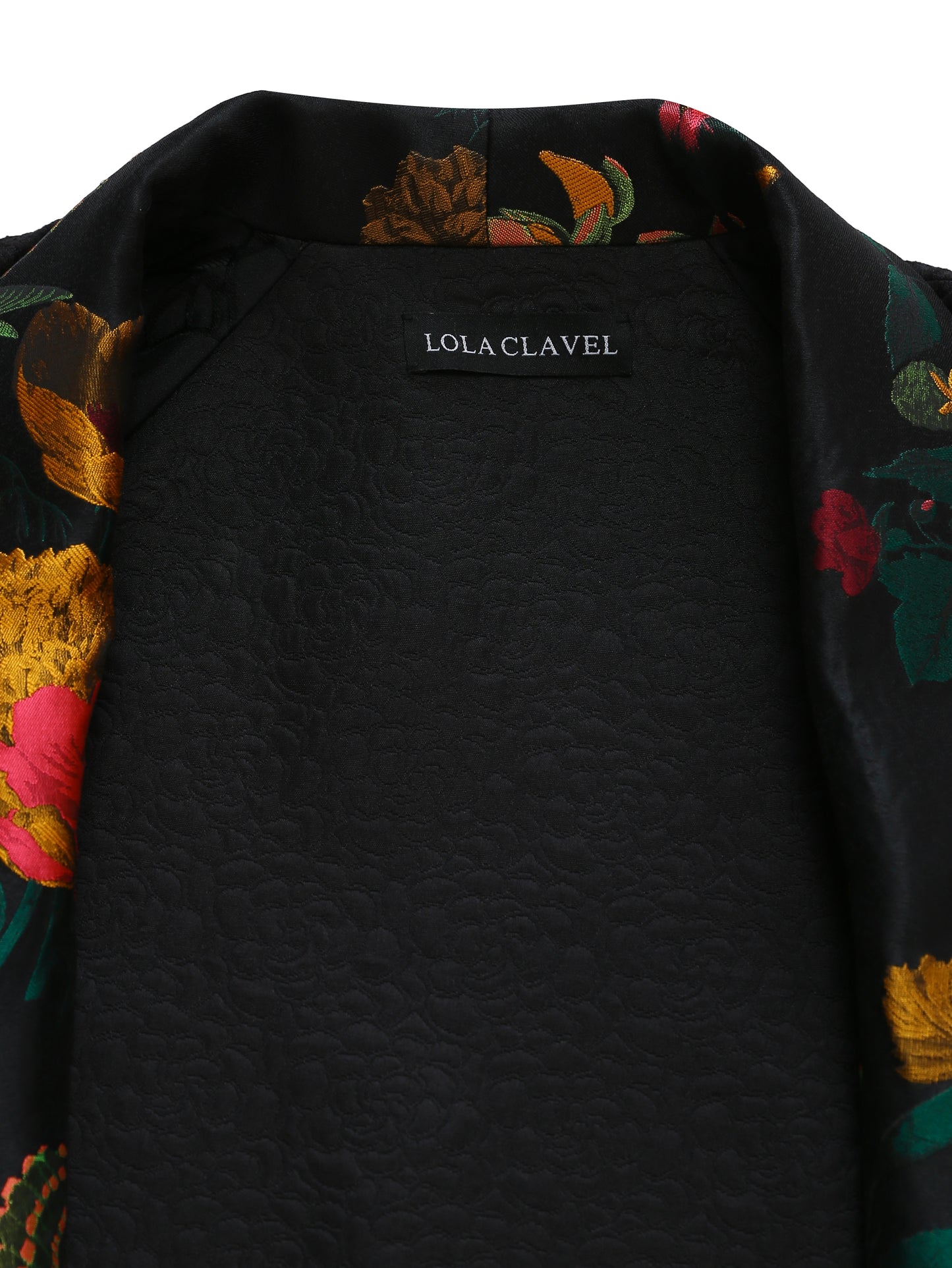Close-up of the floral jacquard lining inside the reversible kimono jacket, showcasing vibrant botanical patterns in gold, pink, and green tones.
