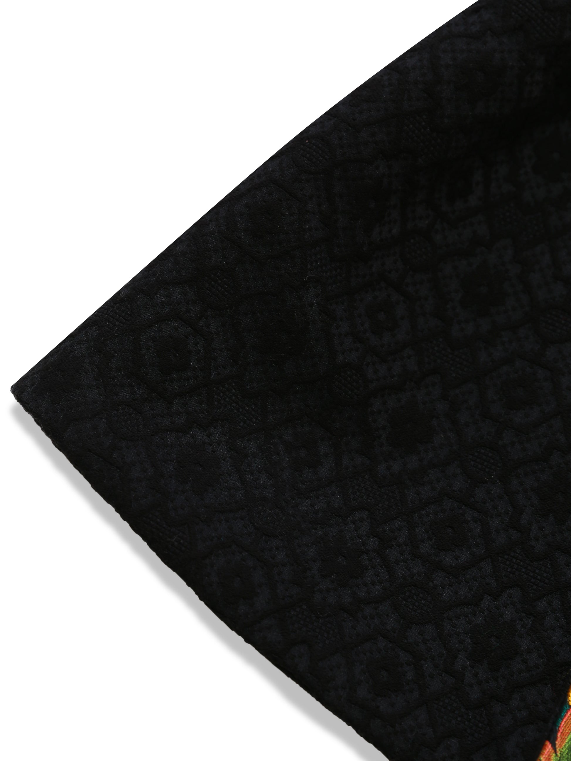 Macro view of the black brocade outer fabric, revealing the intricate woven motif and subtle sheen of the reversible kimono jacket