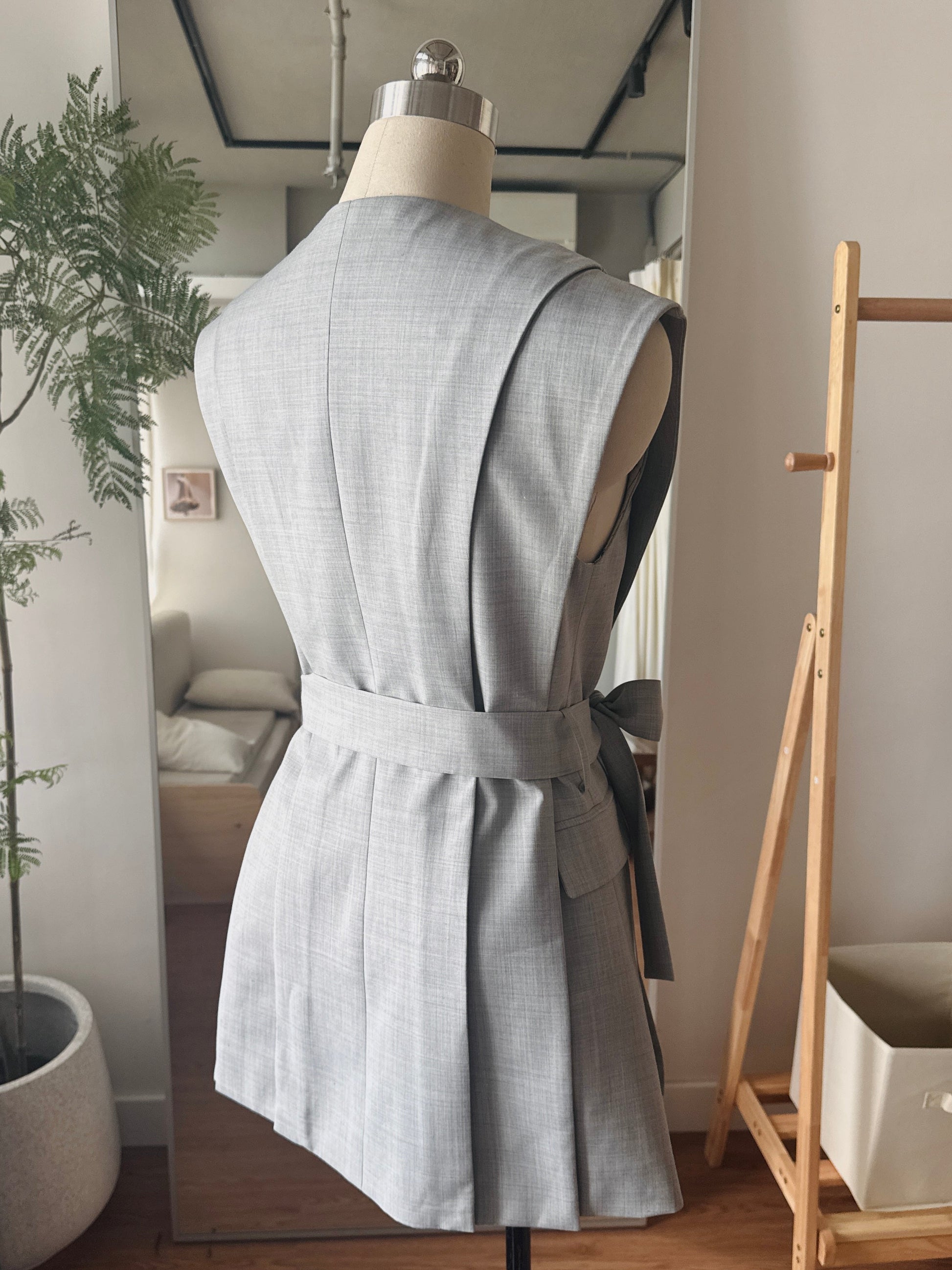 Back view of the Jeanne d’Arc grey vest showing structured tailoring and refined silhouette.