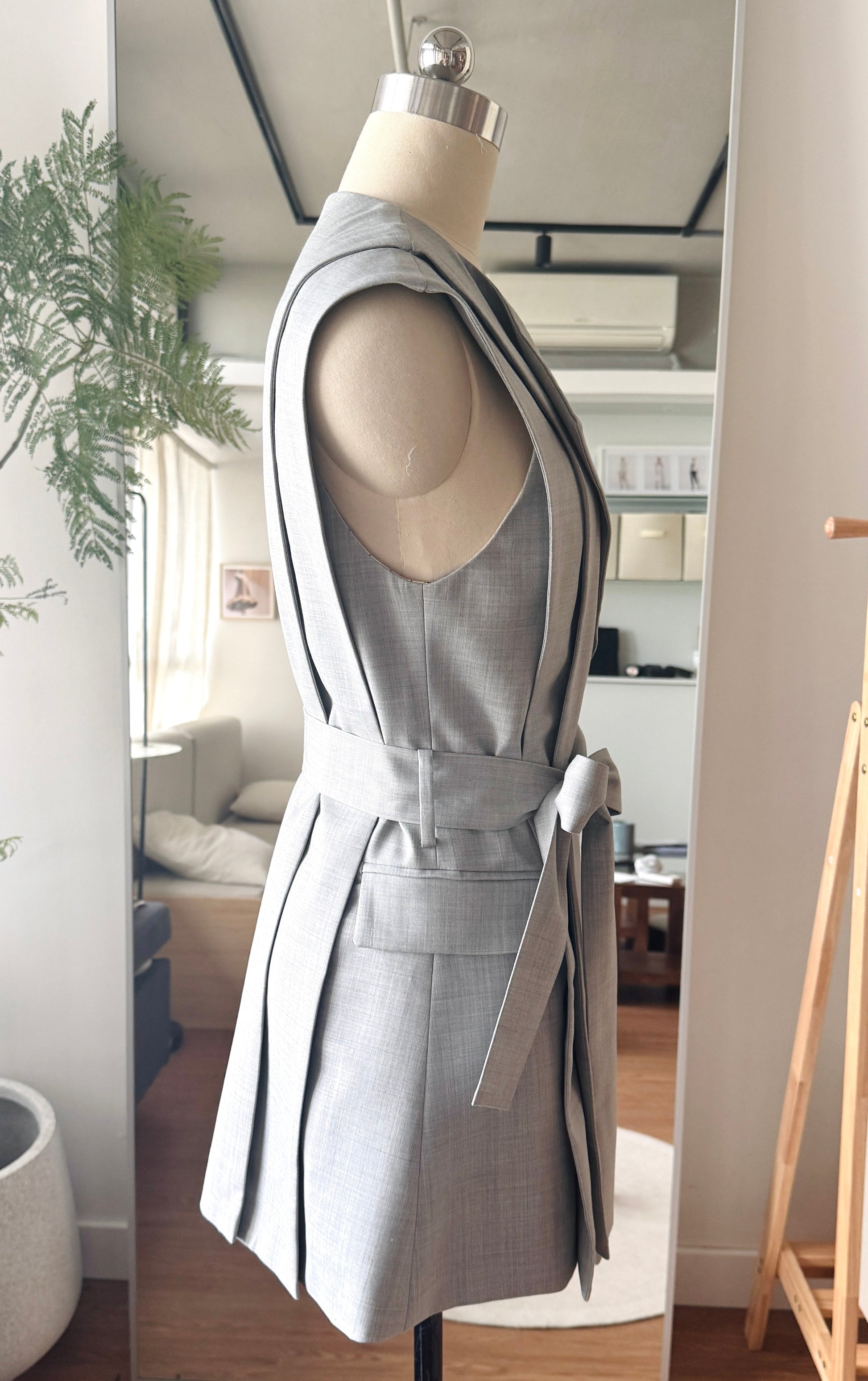 Side view of the grey Jeanne d’Arc vest highlighting sharp contours and contemporary design.